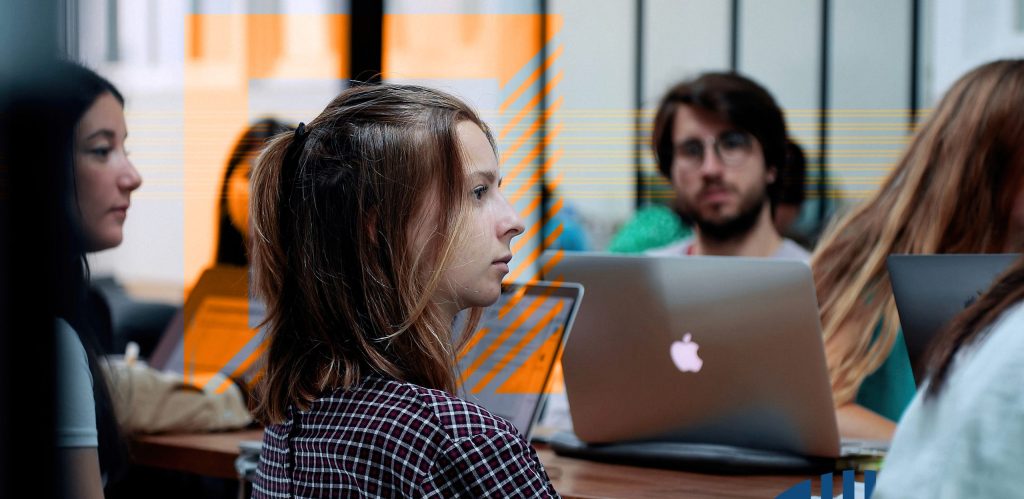 student listening to a lecture in front of a mac computer